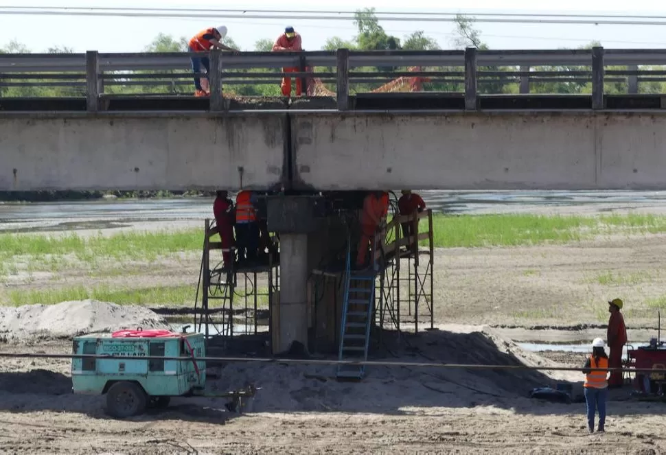ARDUA LABOR. Obreros de la Dirección Nacional de Vialidad trabajan con máquinas en la reparación del puente sobre el río Gastona, al norte de Concepción. la gaceta / foto de Osvaldo Ripoll