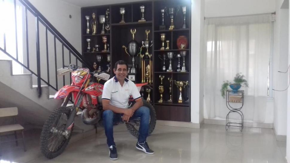 CONQUISTAS. Gustavo Almada, la moto y la sala de trofeos de su casa.