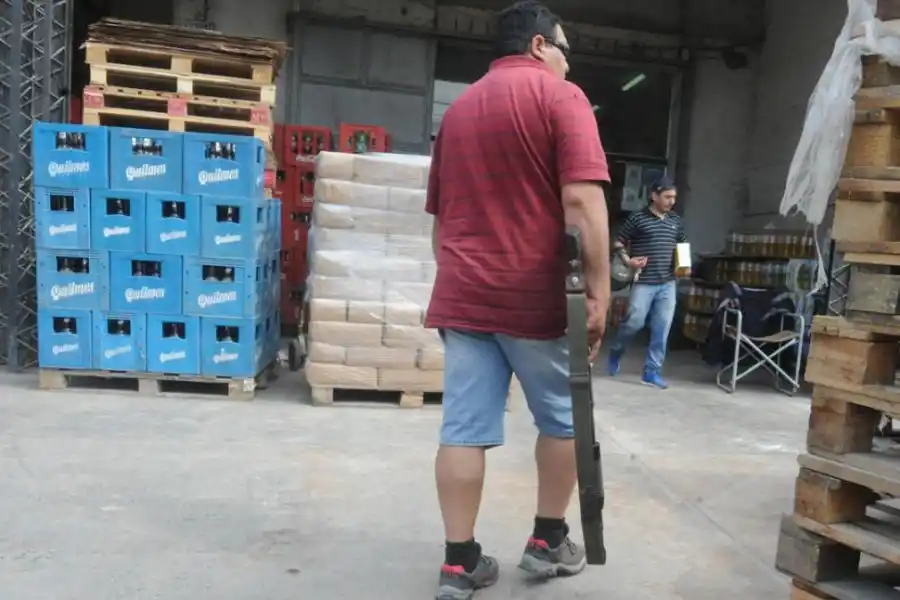 FUERTE CUSTODIA. Un empleado de la distribuidora vigila la entrada del comercio empuñando una escopeta. LA GACETA / FOTO DE ANTONIO FERRONI.-