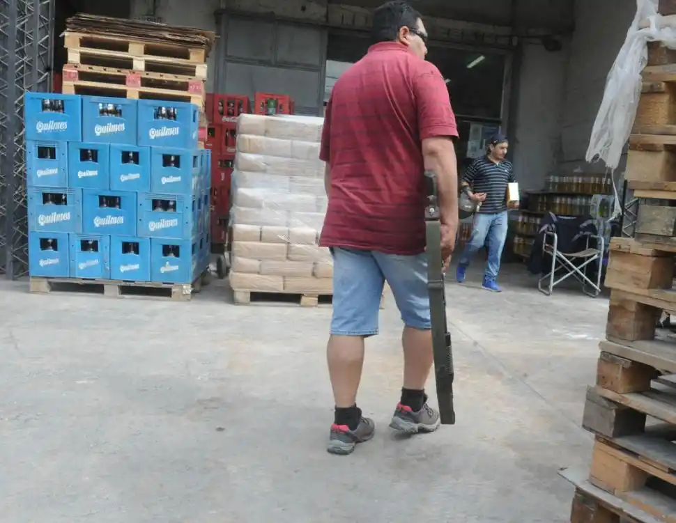 FUERTE CUSTODIA. Un empleado de la distribuidora vigila la entrada del comercio empuñando una escopeta. LA GACETA / FOTO DE ANTONIO FERRONI.-