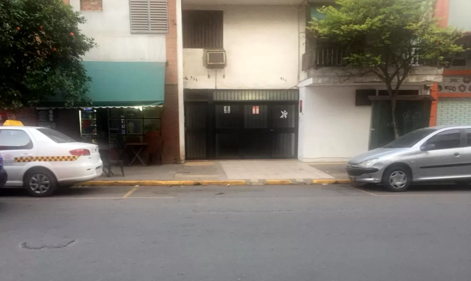 PARA DE TAXI. El portón tiene dos carteles que dicen Prohibido estacionar.