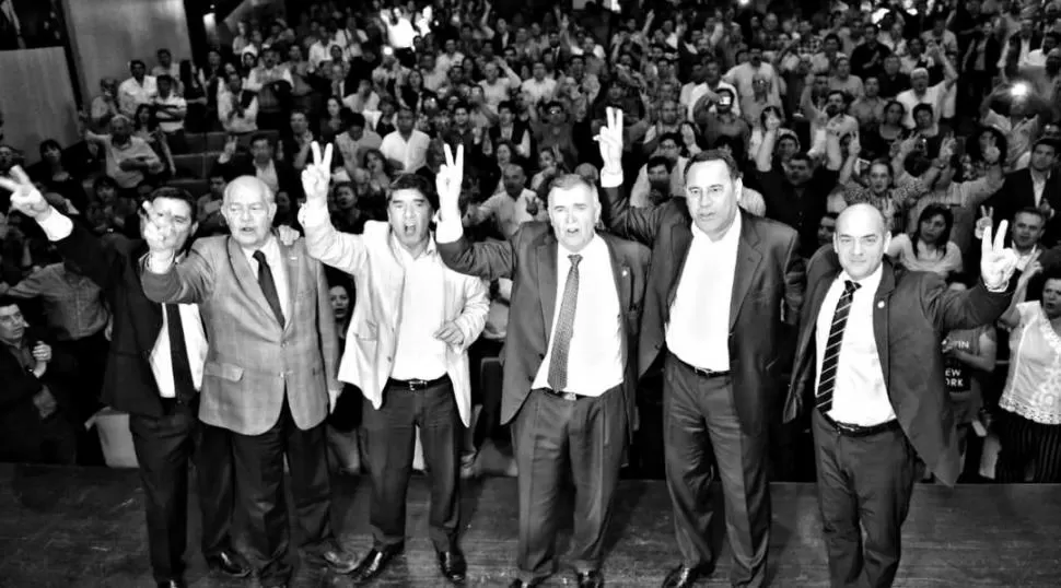 LA SEÑAL DE LA V. Jaldo y los ministros manzuristas cantan la marcha peronista en el salón de actos de la filial Tucumán del Partido Justicialista. prensa jaldo