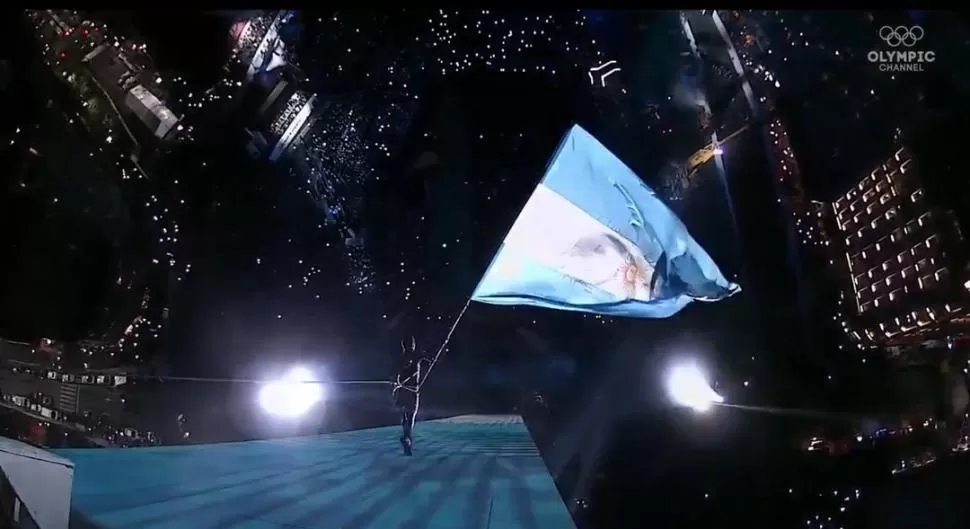 MAJESTUOSO. Un equilibrista bajó caminando por el Obelisco con la bandera argentina durante el acto realizado anoche. Olympic Channel