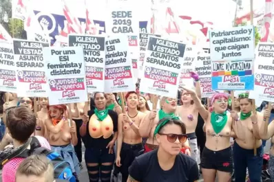 Mujeres con el torso desnudo marcharon frente a una iglesia, en Trelew