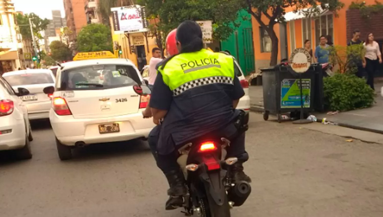 Una policía en moto, sin casco ni patente