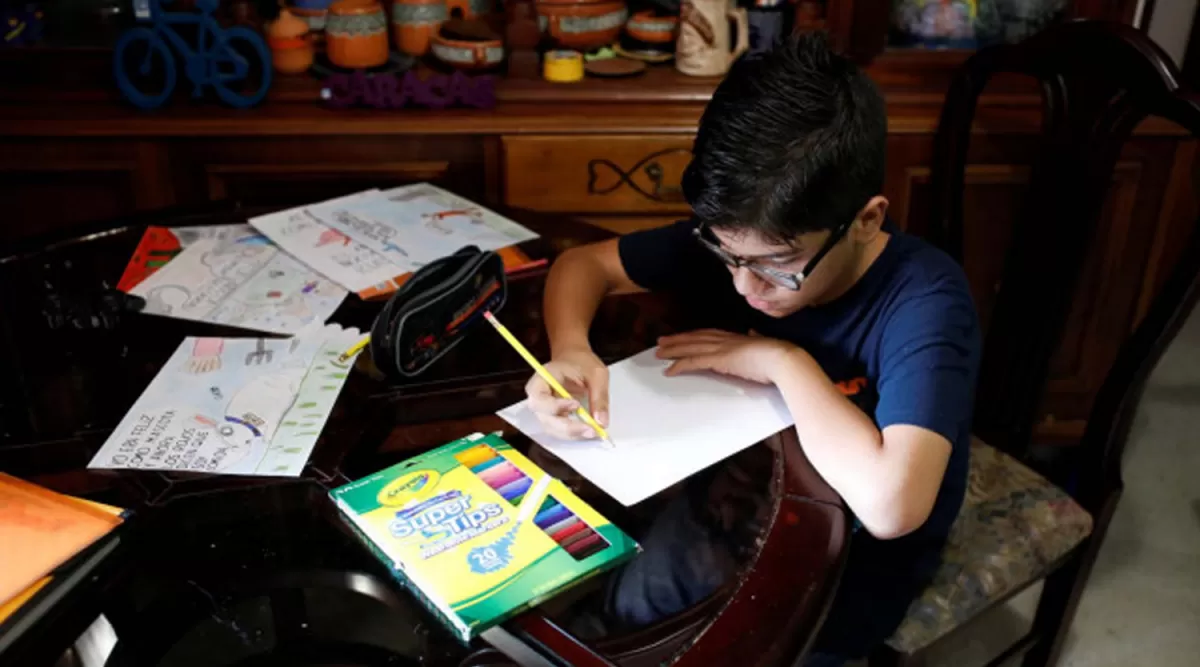 CONCENTRACIÓN. El adolescente Gabriel Moncada aparece en plena tarea creativa en el living de su casa.