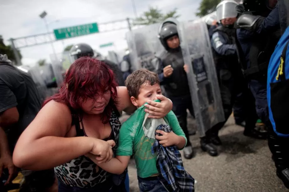 FORCEJEOS. Una hondureña protege a su hijo durante los incidentes. fotos reuters