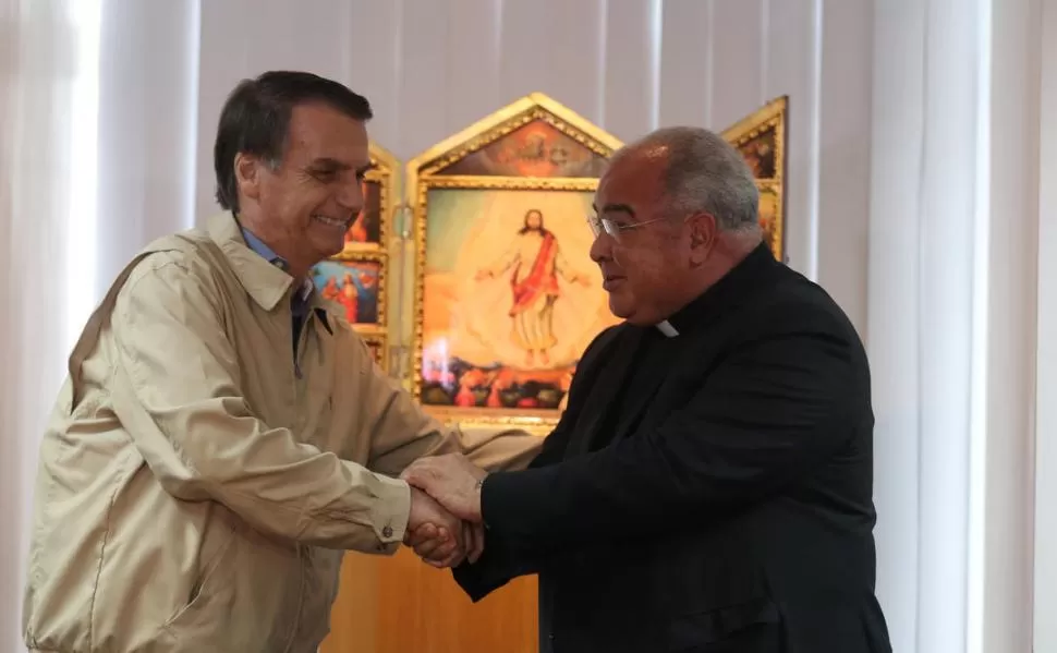 CAMPAÑA. Jair Bolsonaro recibe el saludo del arzobispo Dom Orani. reuters