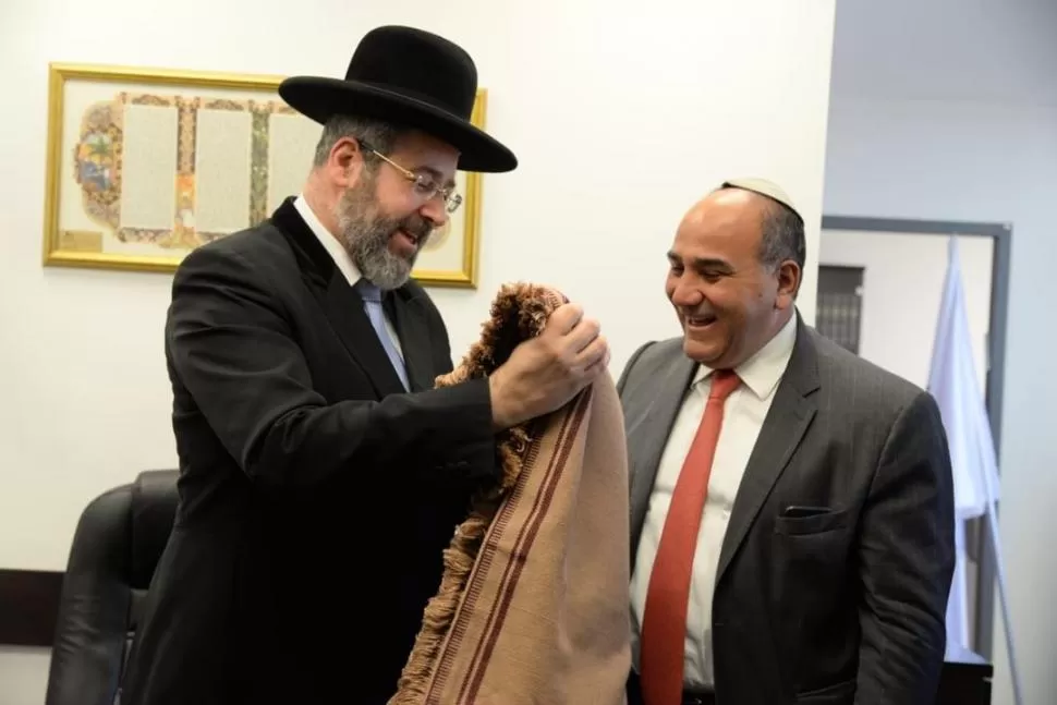 PONCHO Y SONRISAS. El gran rabino de Israel, David Lau, recibe una prenda tradicional de Manzur, con kipá. Fotos gentileza Leonardo Kremenchuzky