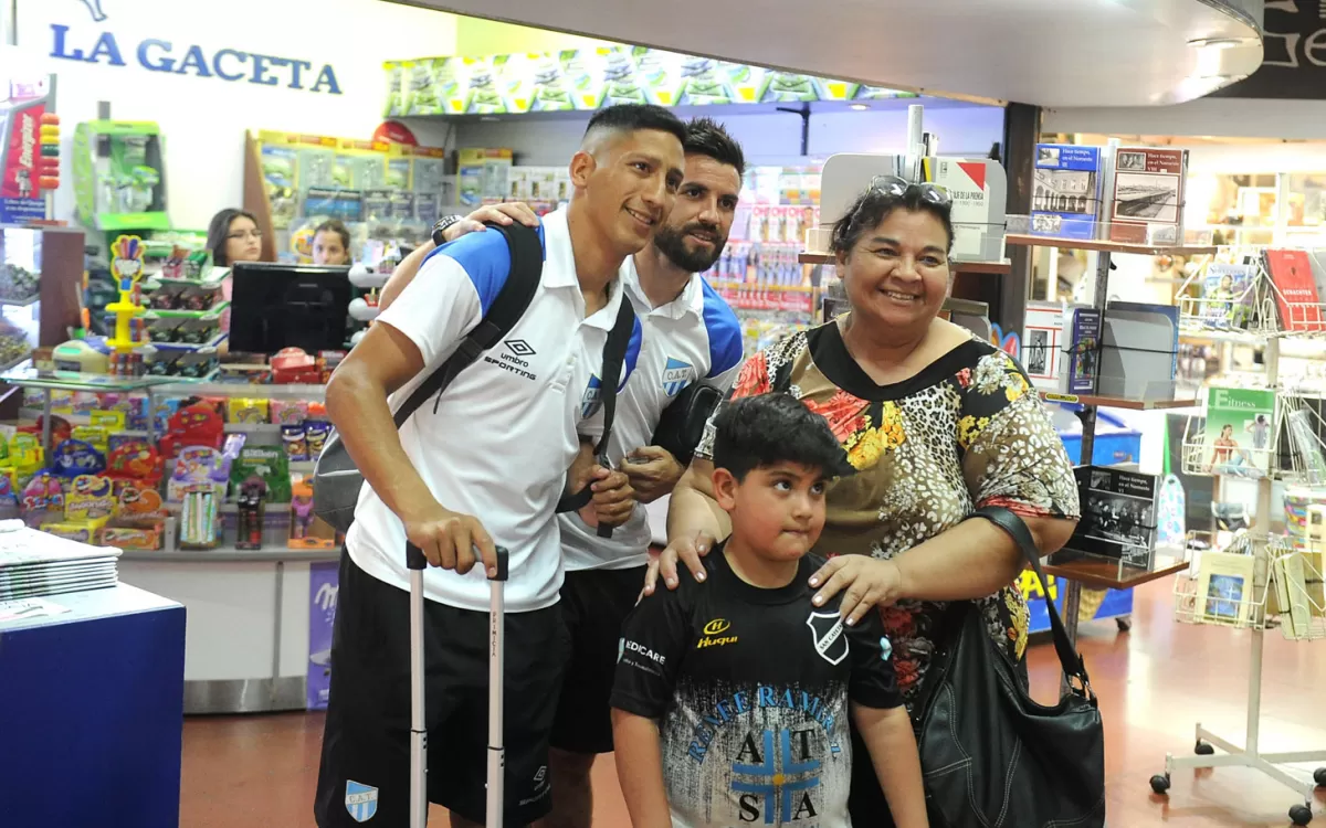 SOLICITADOS. San Román y Aliendro acepan felices tomarse una foto con un niño y su madre, ayer en el aeropuerto. LA GACETA/FOTO DE HÉCTOR PERALTA