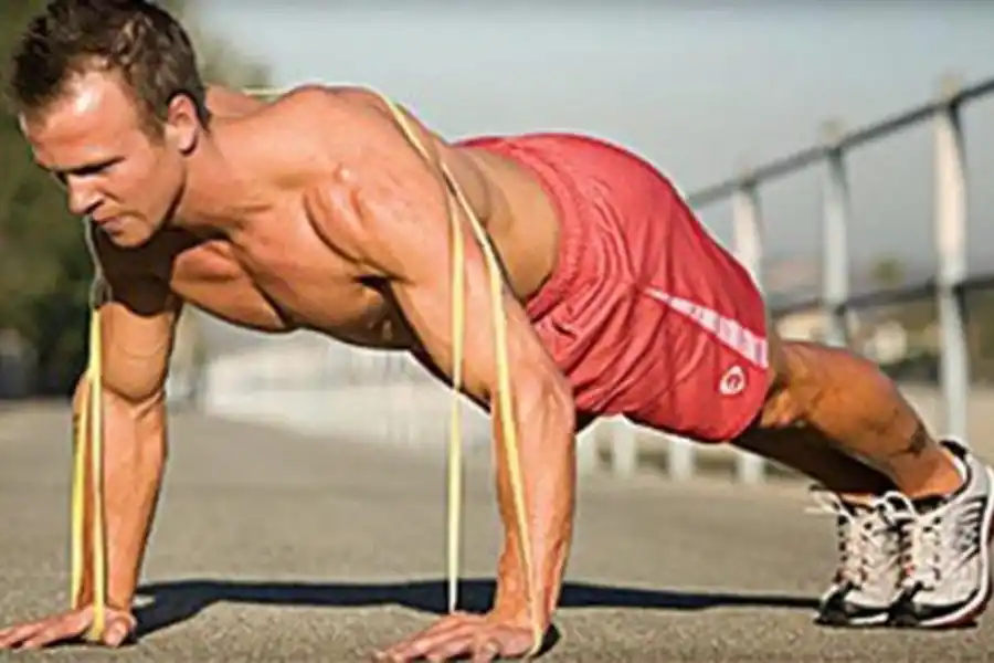 FLEXIONES DE BRAZOS. Acostado boca abajo con la banda centrada en la espalda, la banda se tensa. Apoyamos las manos en el suelo, y realizamos flexión de brazos, de esta manera la banda ofrecerá resistencia.