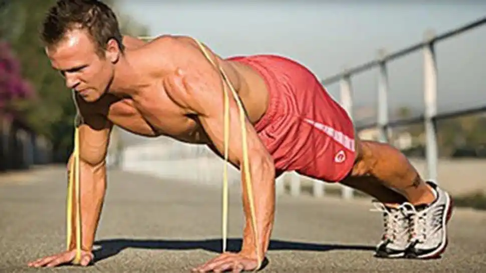 FLEXIONES DE BRAZOS. Acostado boca abajo con la banda centrada en la espalda, la banda se tensa. Apoyamos las manos en el suelo, y realizamos flexión de brazos, de esta manera la banda ofrecerá resistencia.