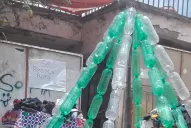 Armaron un árbol de navidad con botellas y regalan ropa para los más necesitados