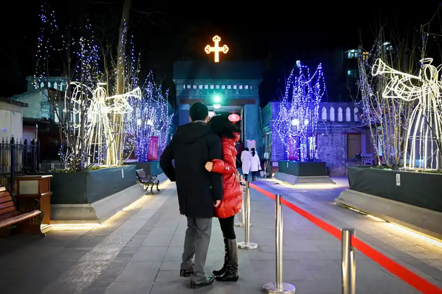 Una pareja de toma una fotografía mientras se preparan para entrar a misa en la iglesia católica de Beijing, China.