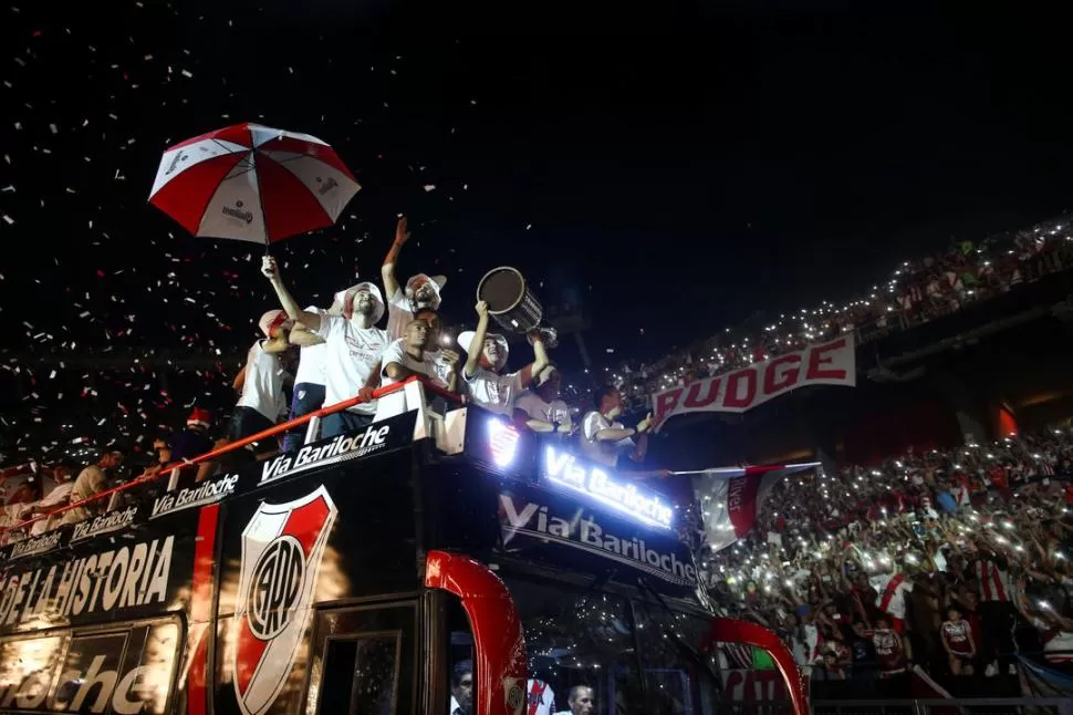 LA VUELTA OLÍMPICA EN COLECTIVO. Los jugadores mostraron la Copa Libertadores y celebraron junto con los hinchas que llenaron el Monumental. reuters