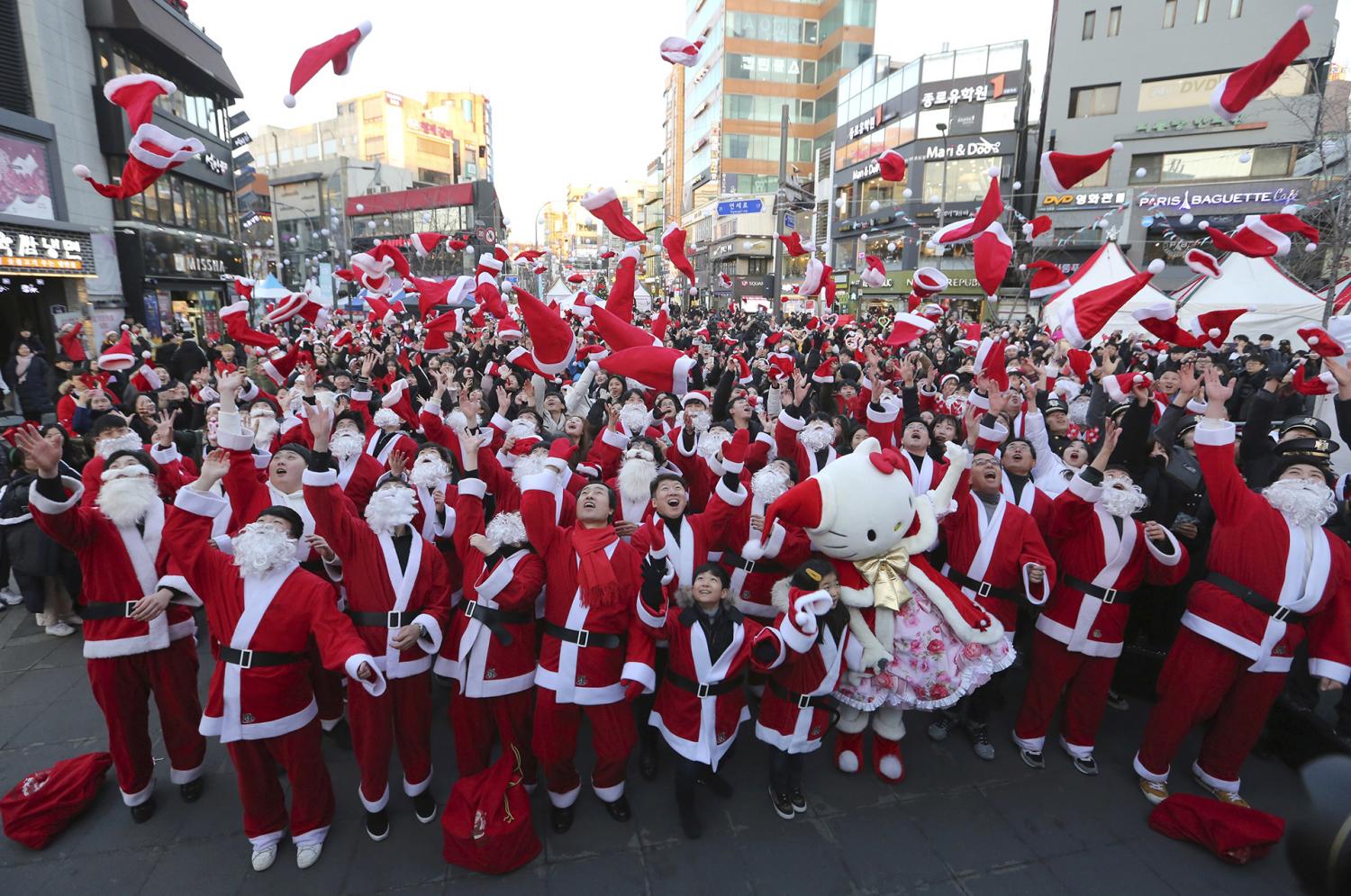 Voluntarios disfrazados de papá Noel arrojan sus sombreros en el centro de Seúl, Corea del Sur.