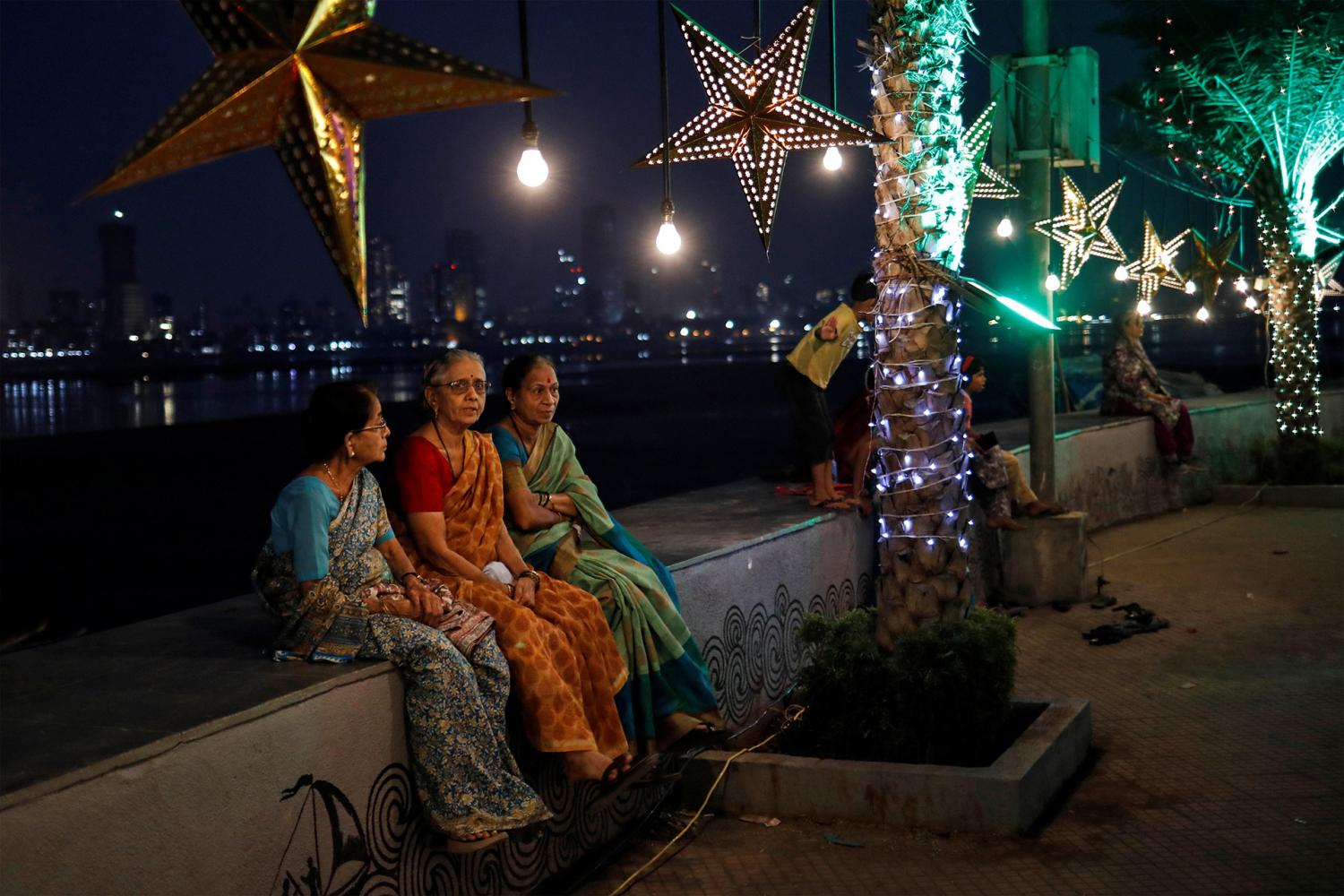 En India, tres mujeres aguardan la llegada de la medianoche en en Mumbai. REUTERS