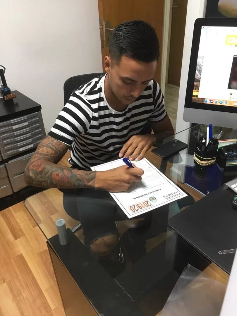 RÚBRICA. Fernando Barrientos firma en el contrato que lo liga al “Santo”.  