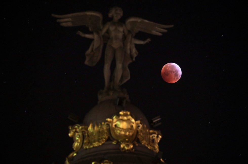 La superluna de sangre vista junto a la estatua de la 'Victoria Alada' en Madrid (España). SERGIO PEREZ REUTERS