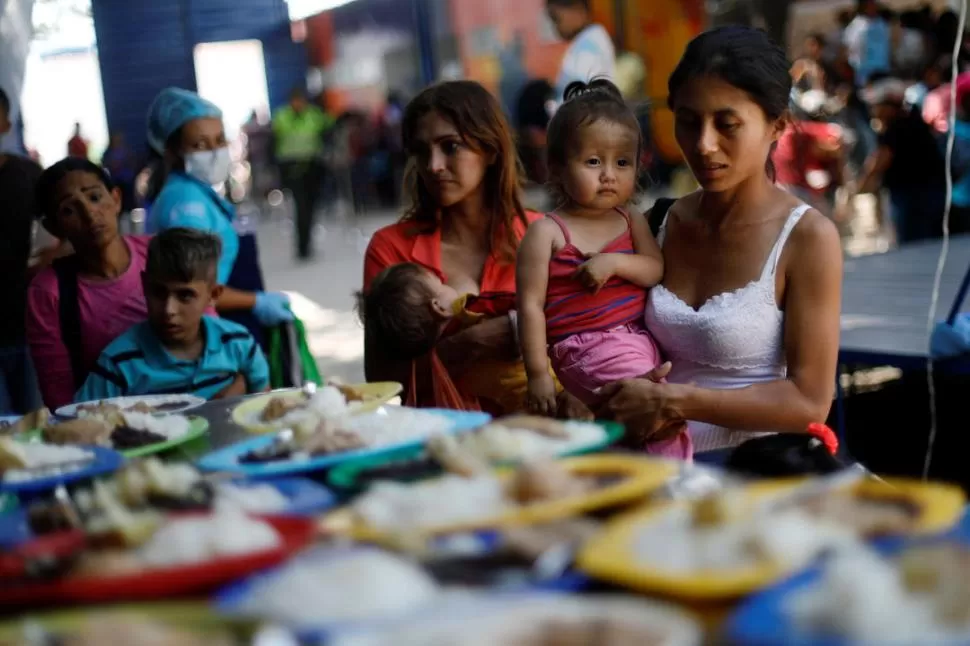 EL CALVARIO DE LOS REFUGIADOS. Familias venezolanas se preparan para almorzar en Cúcuta (Colombia). reuters