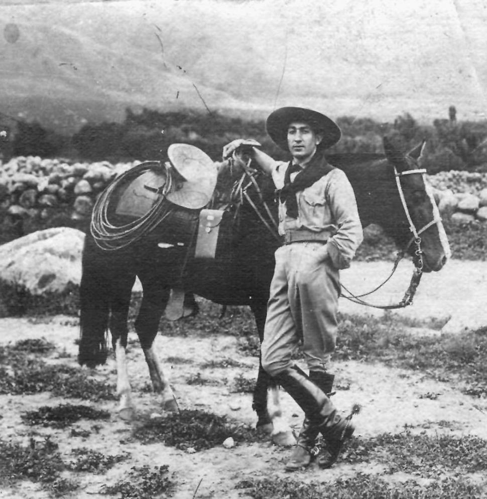LUIS POSSE. En los años mozos, el fotógrafo-jinete posa en Tafí del Valle con sombrero de “cowboy”, botas y espuelas. De la montura, cuelga la cámara