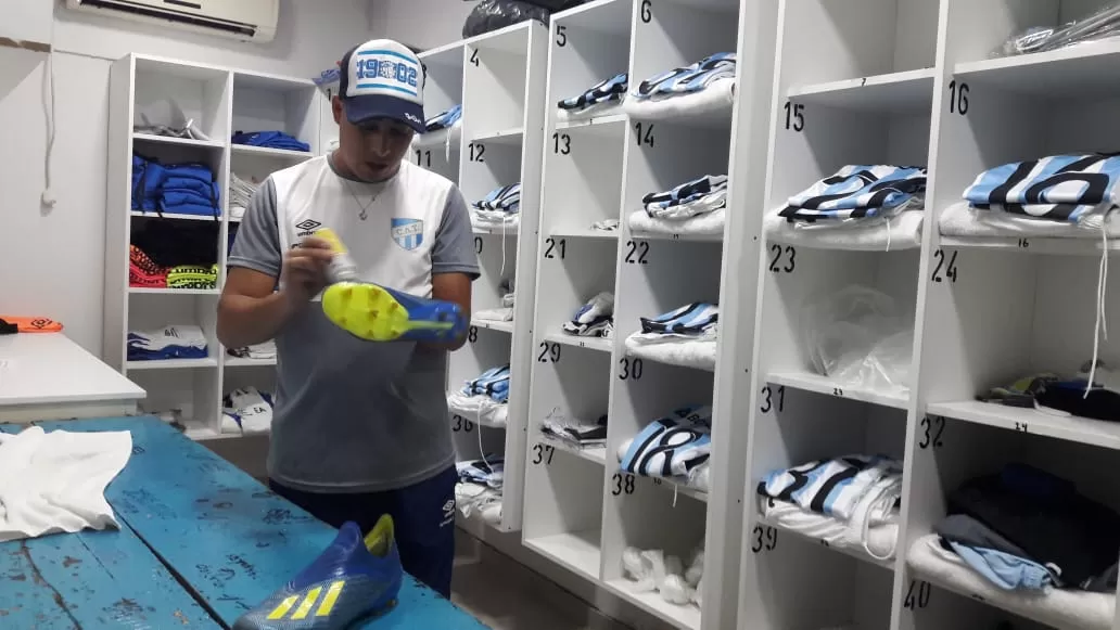 PUESTA A PUNTO. Marcelo Albrecht, uno de los utileros de Atlético, prepara los botines en la intimidad del vestuario. La lluvia lo mantuvo atento al estilo de calzado que elegiría usar cada futbolista. 