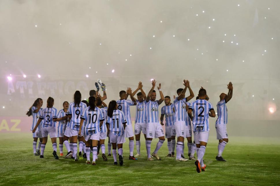 GRAN INICIATIVA. El primer equipo de Atlético, saltó al campo con las jugadoras de su equipo femenino. Ellos y ellas, junto al equipo de River también, posaron para la tradicional foto de los equipos.  