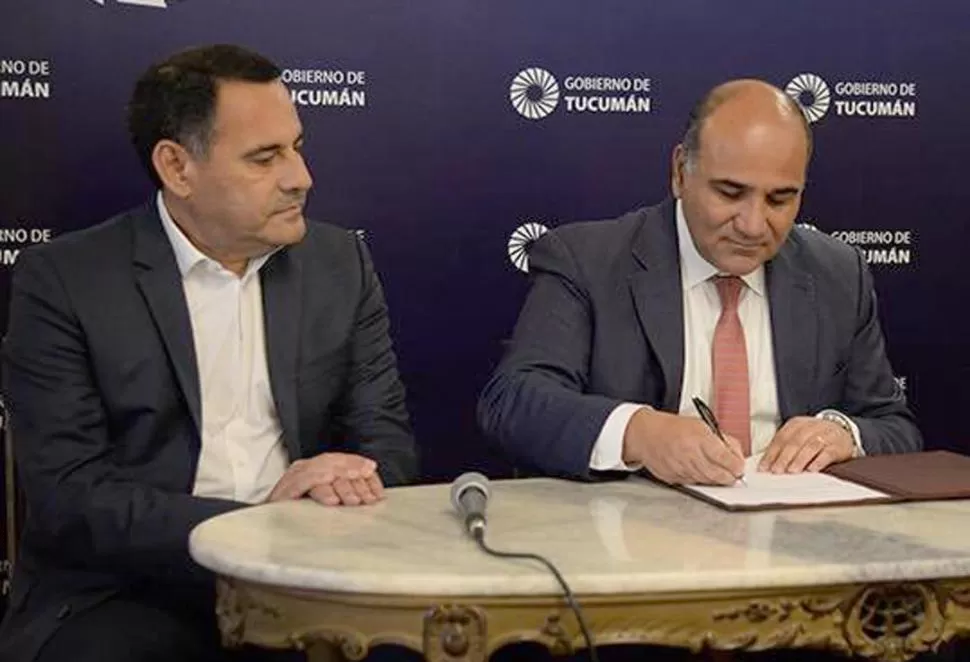 EL GOBERNADOR, Y EL MINISTRO DE GOBIERNO Y JUSTICIA. Regino Amado observa cómo Juan Manzur firma un decreto en un acto reciente. comunicación pública
