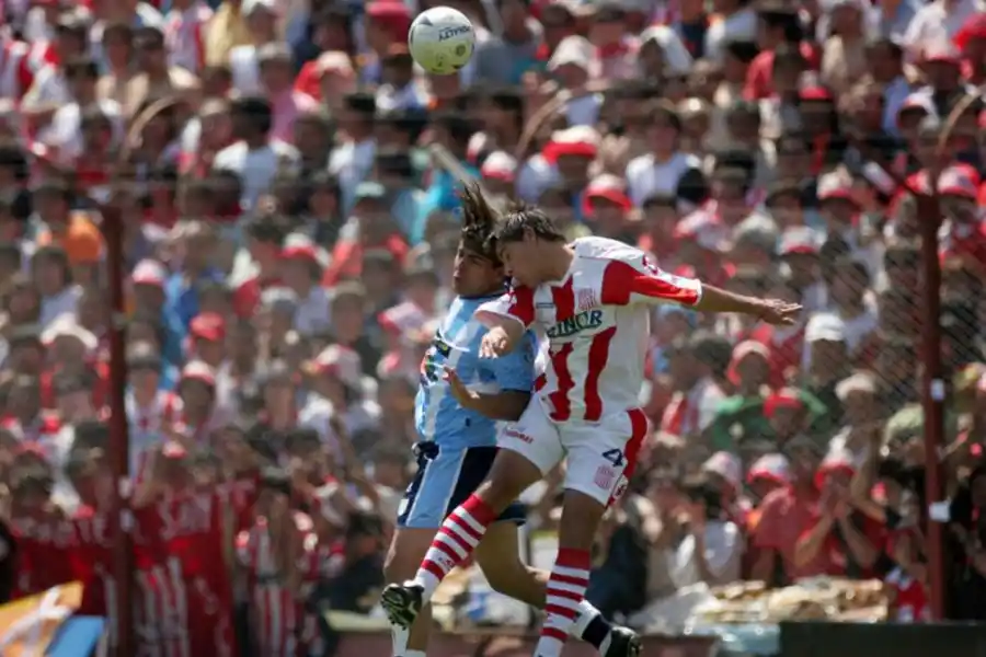 MAÑANA FATÍDICA. Fernando Robles salta a cabecear con Luciano González, de San Martín. Octubre de 2005: Atlético perdió el clásico.  