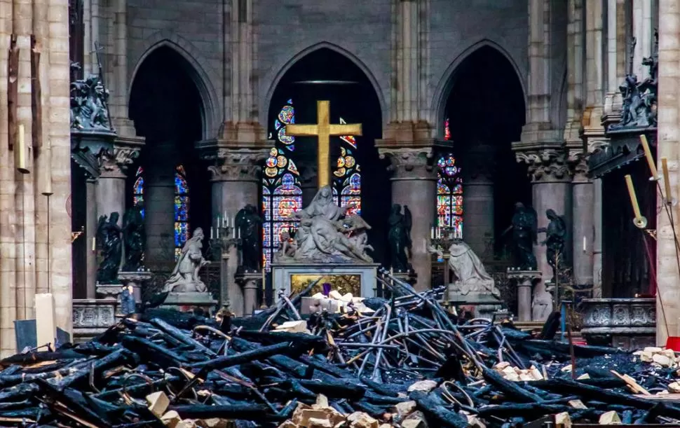 ENTRE ESCOMBROS. Envueltos en llamas, los soportes de madera del techo de la catedral parisina se derrumbaron.  Reuters