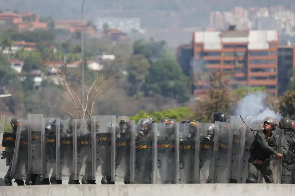 CARGA. La Guardia Nacional Bolivariana lanzó granadas de gas lacrimógeno a los manifestantes.  fotos Reuters