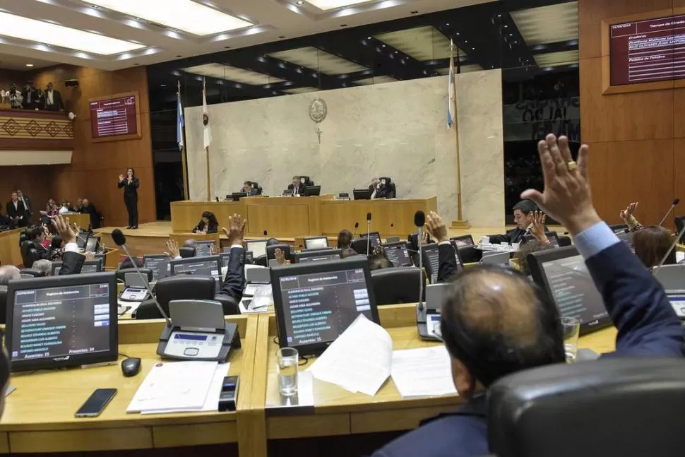 ACTIVIDAD PARLAMENTARIA. Desde sus bancas, legisladores levantan la mano para dejar constancia de su votación, en la sesión del 22 de marzo pasado.  