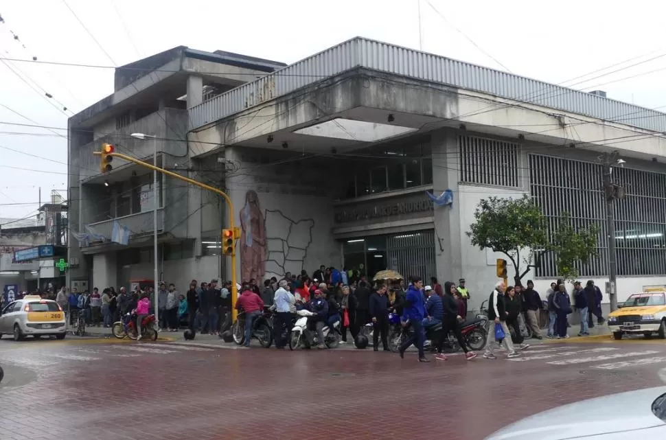 FUERA DE LA SUCURSAL DE LA CAJA POPULAR. Cientos de beneficiarios de los “planes” de $ 3.000 mensuales hicieron fila el viernes pasado en Concepción. la gaceta / foto de Osvaldo Ripoll