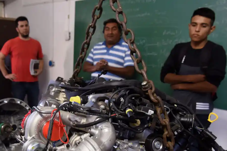LA JOYA. Mauro, el primero a la derecha de la imagen, mira el motor Mercedes Benz donado a la escuela.