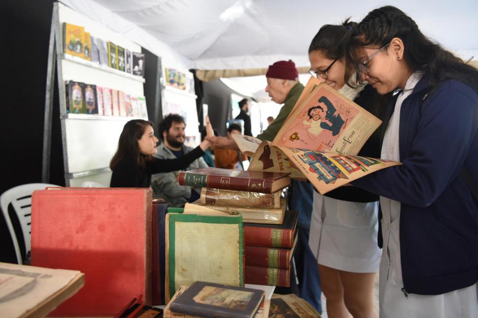 -  CHICOS QUE LEEN. Denisse y Mayte revuelven uno de los puestos. Muchos adolescentes recorren la Feria.-