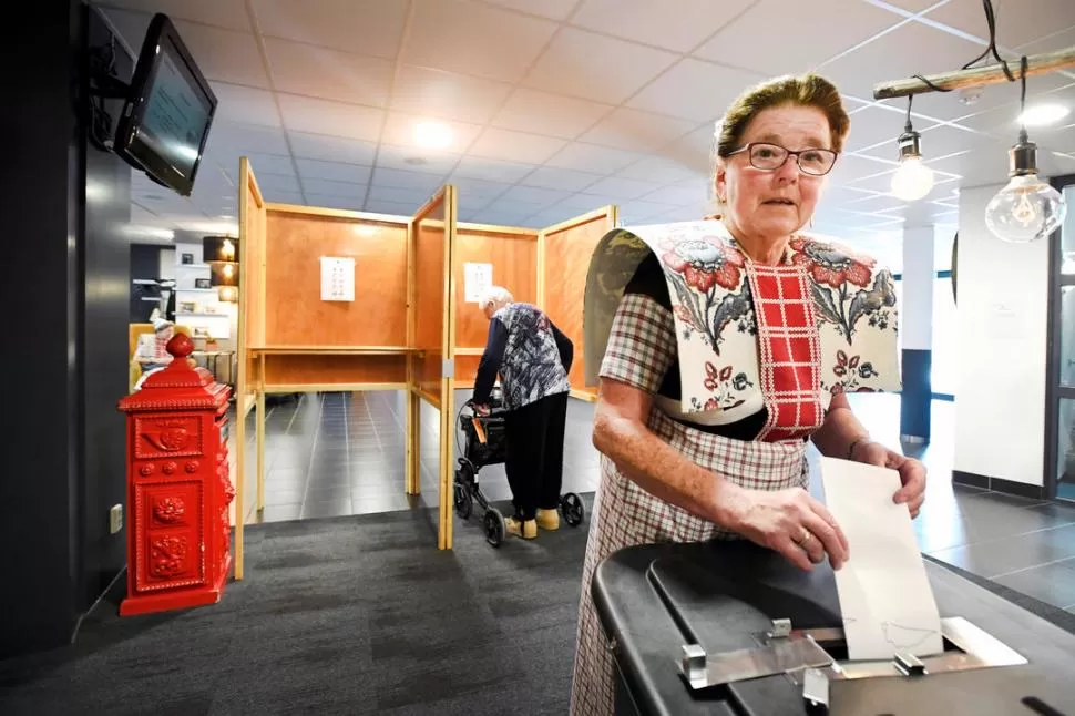 TRADICIONES. Una mujer vestida con traje ancestral campesino deposita su voto en la estación de Bunschoten-Spakenburg, Holanda. Reuters