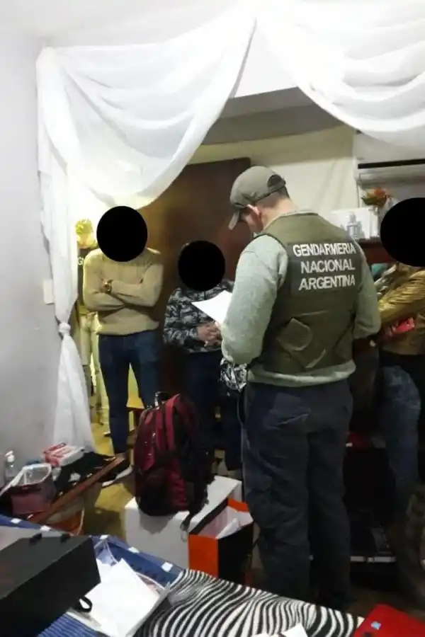 PROCEDIMIENTO. Un gendarme registra el lugar, frente a varias personas.  