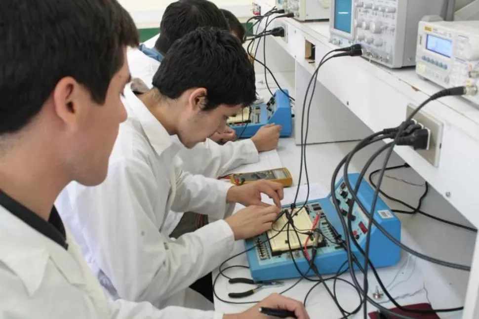 DEL AULA A LA EMPRESA. Estudiantes trabajan con dispositivos electrónicos durante una clase de laboratorio. 