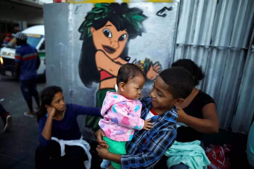 EN TAPACHULA. Adultos y niños provenientes de países de América Central esperan ser atendidos por la Comisión de Asistencia de Refugiados (Comar). reuters