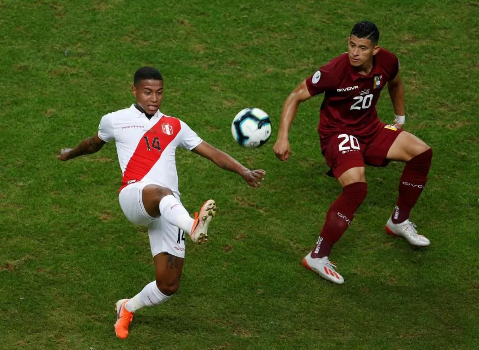 LA MIRADA FIJA. Polo (Perú) y Hernández (Venezuela) se disputan la pelota. Reuters