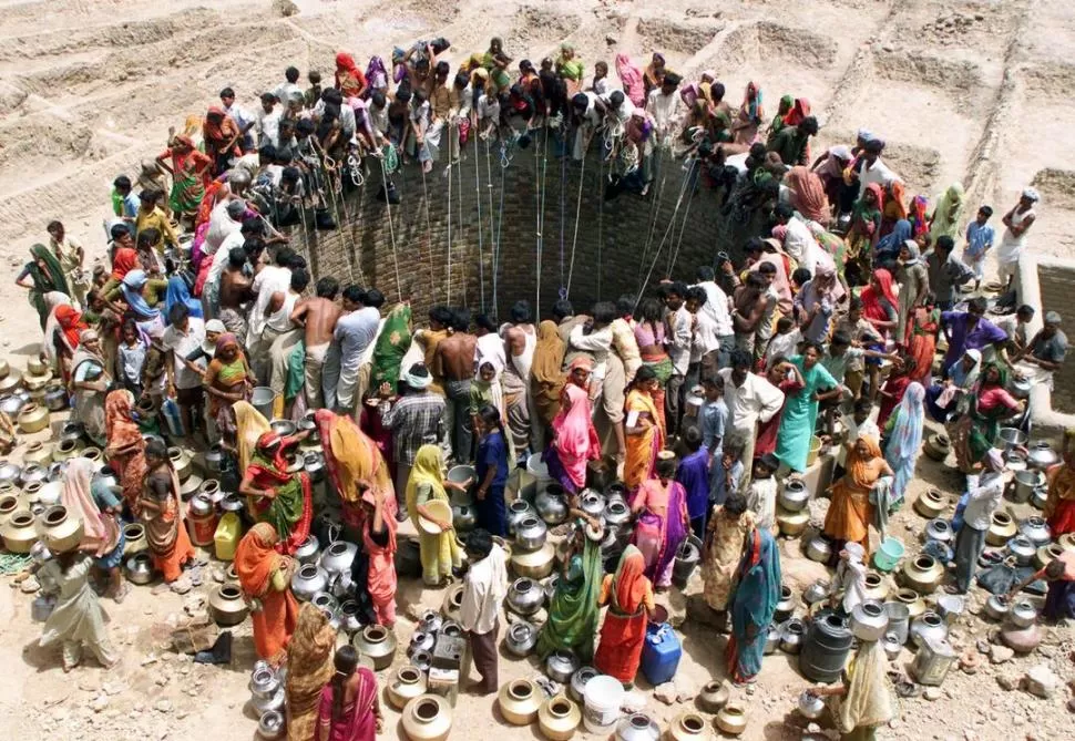 ESCASEZ. Decenas de personas se amontonan para obtener agua, en el estado occidental indio de Gujarat.  reuters