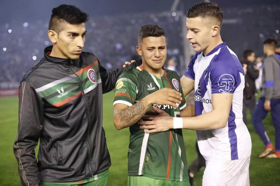 BRONCA. Un jugador de Alvarado consuela a Martín Peralta-centro- que muestra su desconsuelo por el final del encuentro.  telam