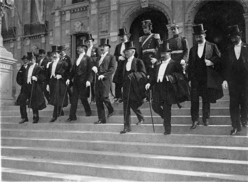 TODOS CON BASTÓN. El presidente Roque Sáenz Peña, con el gobernador Ernesto Padilla y comitiva, en la escalinata de la Casa de Gobierno de Tucumán, en 1913. 