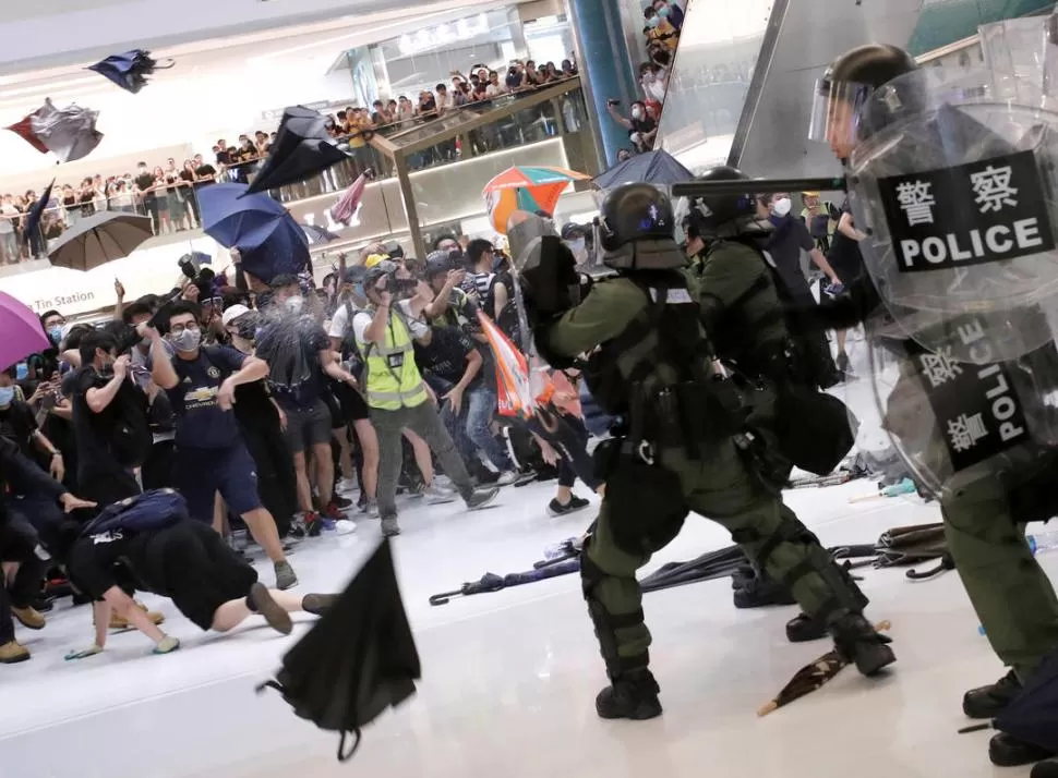 CON PARAGUAS. Enfrentaron a la policía dentro de un centro comercial.  reuters