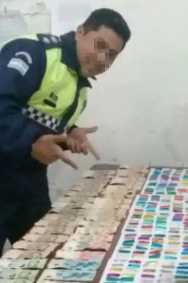 La foto de la polémica. El policía posa junto al secuestro de droga y dinero.