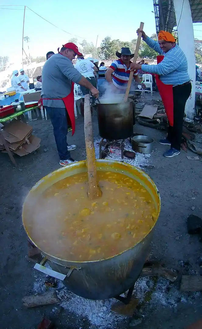 -EN PLENA TAREA. Lo cocineros revuelven el locro en la olla humeante.-