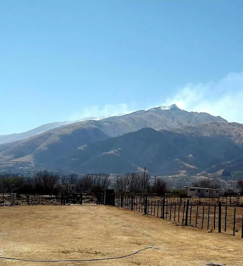 HUMO EN LAS ALTURAS. Desde la zona llana del valle puede observarse el humo que se levanta en los alrededores de la cima del cerro Pabellón. 