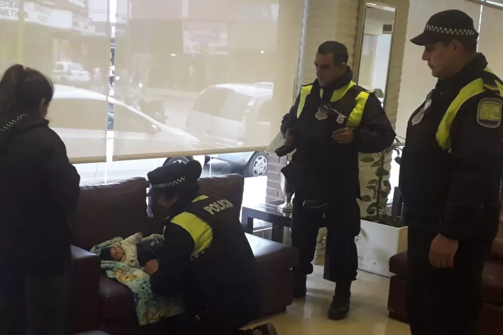 La mujer policía practica las técnicas de reanimación al bebé.