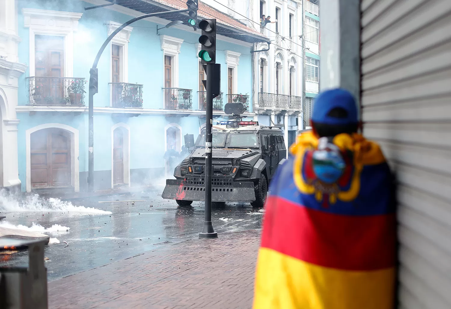 EN QUITO. Un manifestante se escuda de los camiones hidrantes de las fuerzas de seguridad.