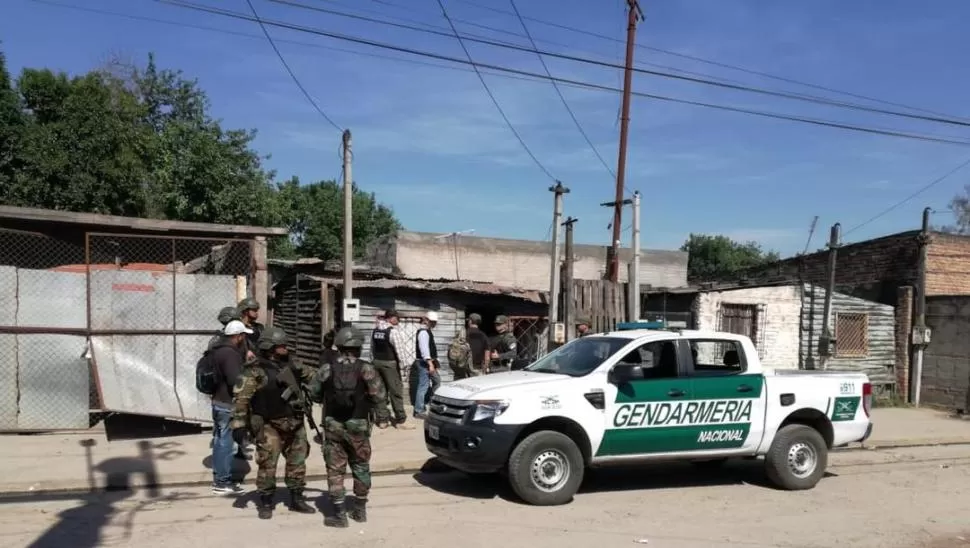 MOVIMIENTO. Agentes de la fuerza de seguridad federal inspeccionan una de la treintena de viviendas identificadas en el operativo.